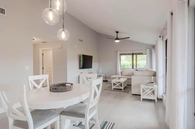 a living room with furniture a flat screen tv and kitchen view