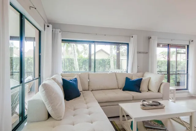 a living room with furniture and large windows