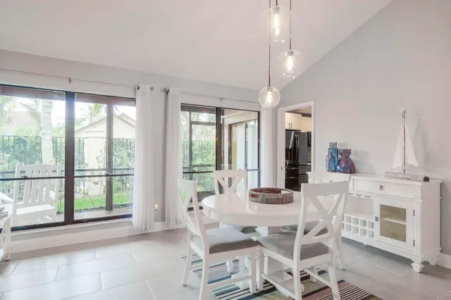 a dining room with furniture a fireplace and large windows