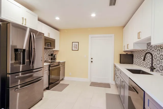 a kitchen with stainless steel appliances granite countertop a refrigerator and a sink