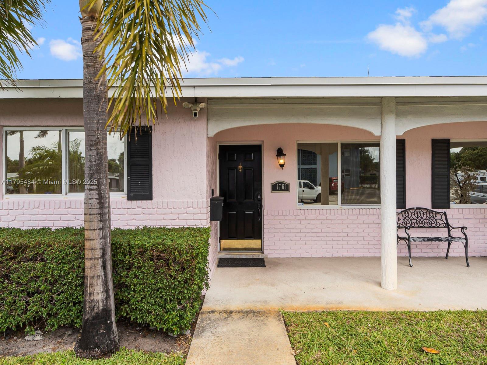 1761 Northeast 52nd Street, Unit 12 Fort Lauderdale, FL 33334 - Photo 19 of 19 a front view of a house with a garden