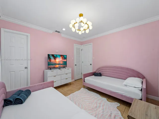 a bedroom with a bed and a chandelier
