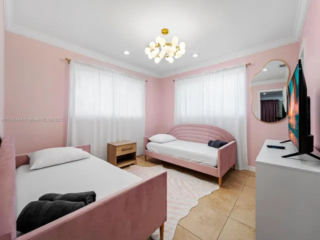 a bedroom with a bed a couch and a flat tv screen