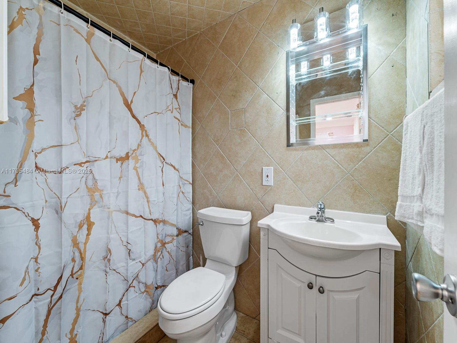 1761 Northeast 52nd Street, Unit 12 Fort Lauderdale, FL 33334 - Photo 6 of 19 a bathroom with a sink mirror and toilet