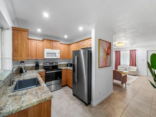 a kitchen with stainless steel appliances granite countertop a refrigerator stove and sink
