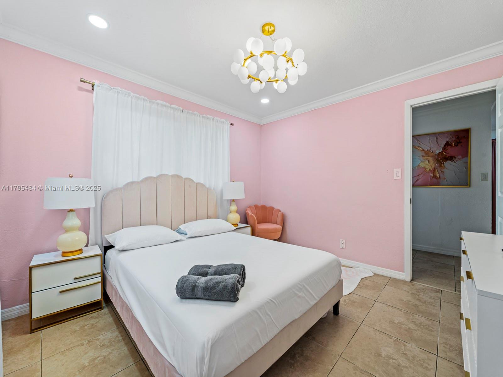 1761 Northeast 52nd Street, Unit 12 Fort Lauderdale, FL 33334 - Photo 10 of 19 a bedroom with a bed and a chandelier