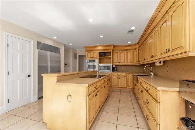 a kitchen with stainless steel appliances granite countertop a refrigerator and a stove top oven