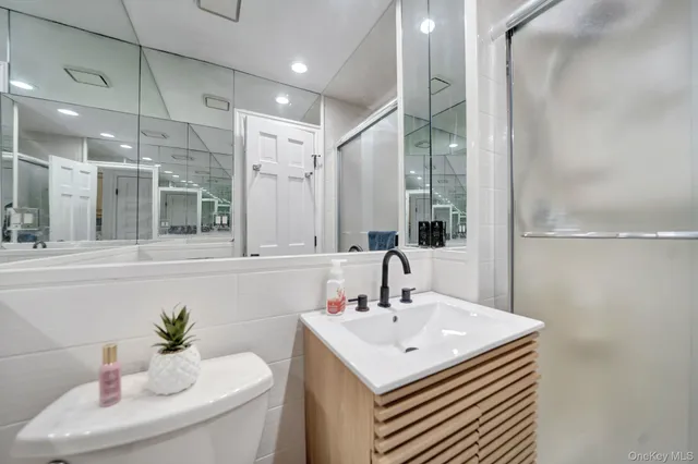 a bathroom with a toilet a sink a mirror and vanity