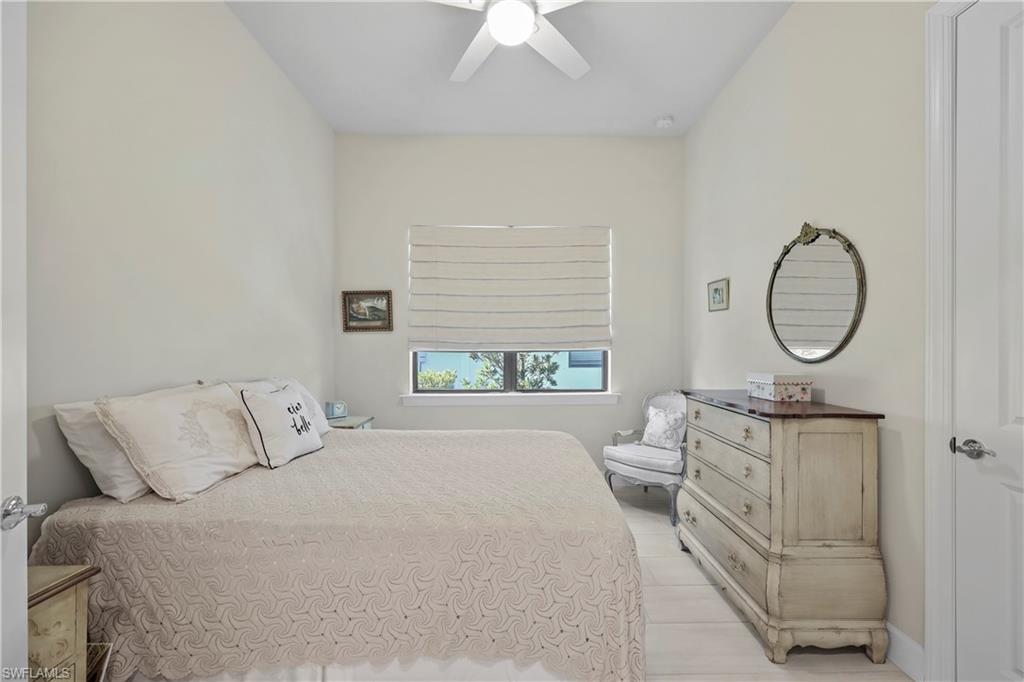 2048 Yellowfin Circle Naples, FL 34114 - Photo 17 of 30 a bedroom with a bed a mirror and a large window