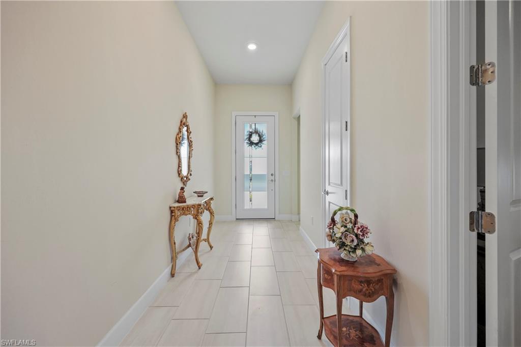 2048 Yellowfin Circle Naples, FL 34114 - Photo 3 of 30 a hallway with two chairs and a gate