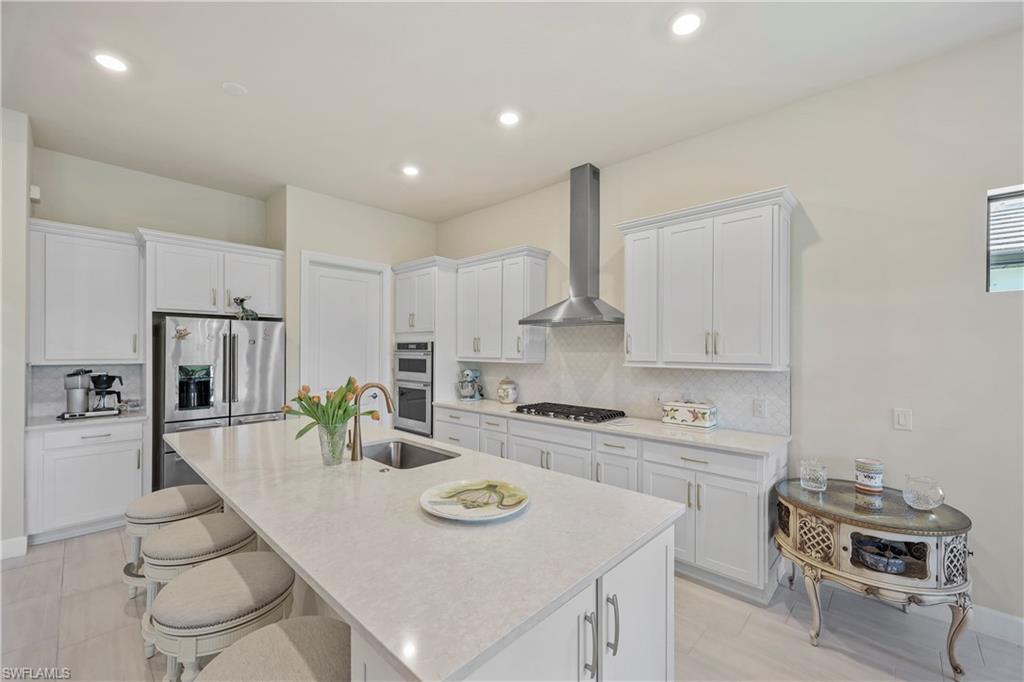 2048 Yellowfin Circle Naples, FL 34114 - Photo 9 of 30 a kitchen with white cabinets and stainless steel appliances