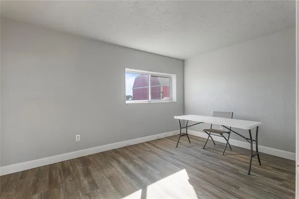 a view of a room with wooden floor and a window
