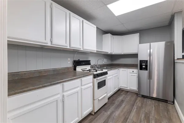 a kitchen with stainless steel appliances granite countertop a refrigerator and a stove top oven