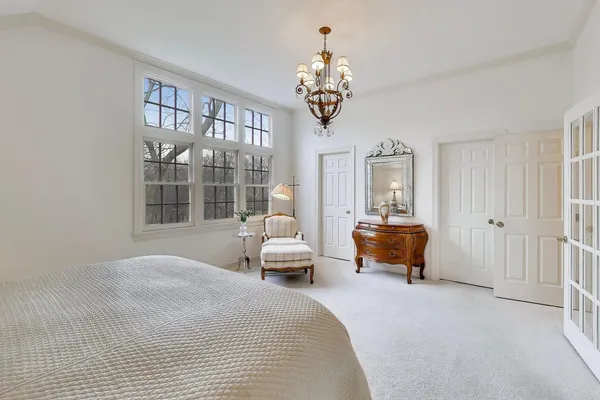 a spacious bedroom with a bed and a chandelier