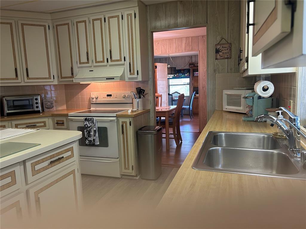 12501 Ulmerton Road, Unit 216 Largo, FL 33774 - Photo 13 of 34 a kitchen with stainless steel appliances granite countertop a sink stove and refrigerator