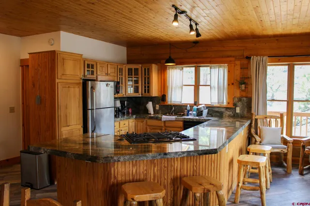 a view of a dining room with furniture a kitchen and chandelier