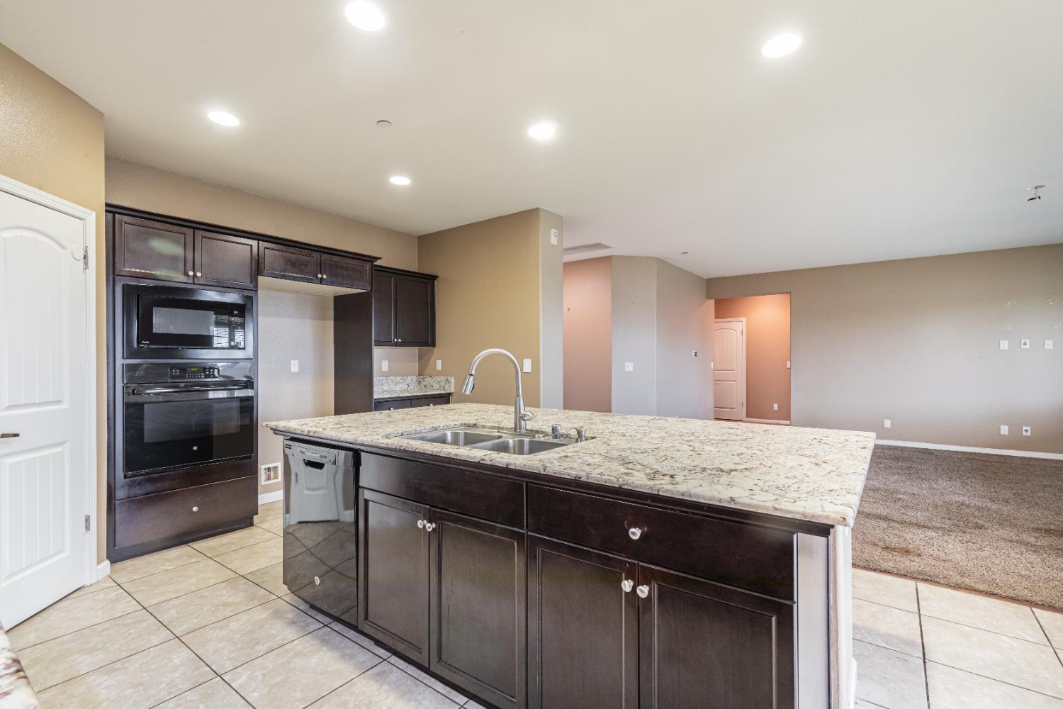 863 Legacy Drive Lemoore, CA 93245 - Photo 15 of 33 a kitchen with stainless steel appliances granite countertop a sink and a refrigerator