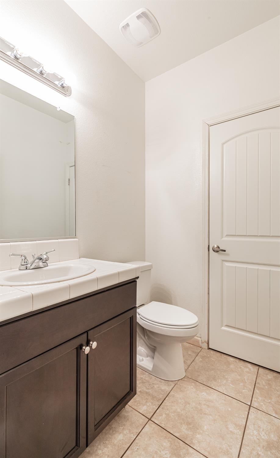 863 Legacy Drive Lemoore, CA 93245 - Photo 17 of 33 a bathroom with a sink a toilet and mirror