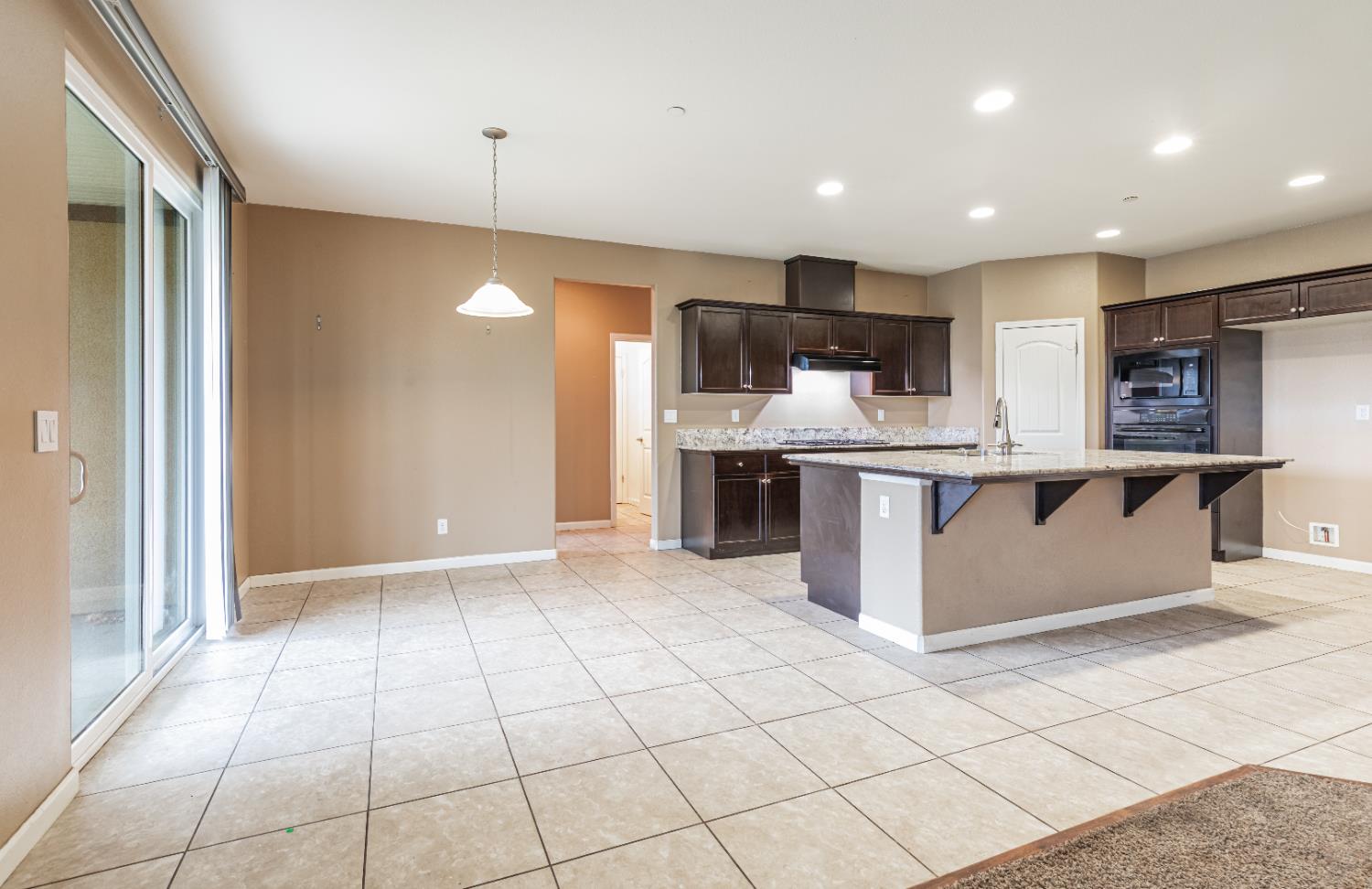 863 Legacy Drive Lemoore, CA 93245 - Photo 5 of 33 a large kitchen with stainless steel appliances granite countertop a stove and a sink