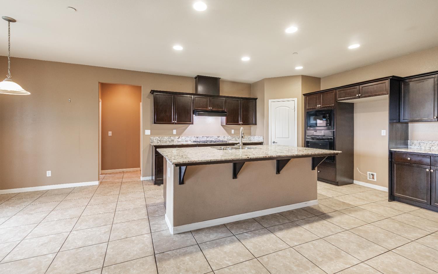 863 Legacy Drive Lemoore, CA 93245 - Photo 7 of 33 a kitchen with stainless steel appliances granite countertop a sink and a refrigerator