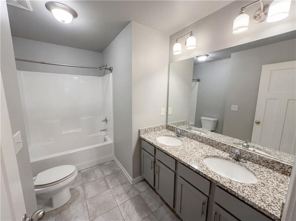 2110 George Bush Lane Jefferson, GA 30549 - Photo 33 of 40 a bathroom with a granite countertop sink toilet and shower
