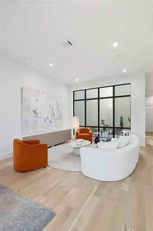 a living room with furniture a table and a large window