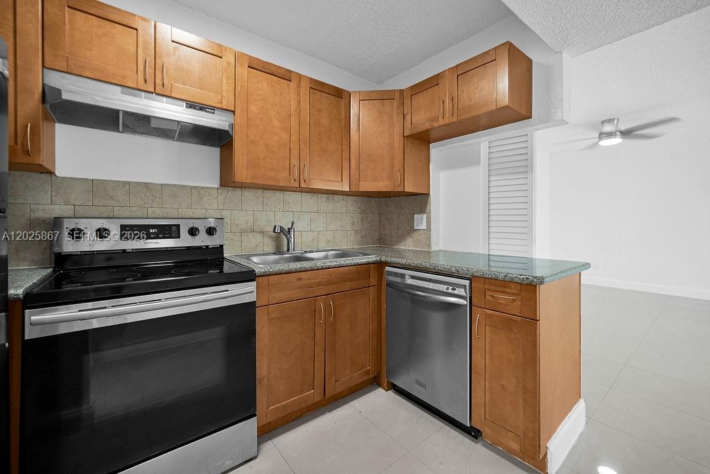 6891 Southwest 7th Street Margate, FL 33068 - Photo 12 of 45 a kitchen with stainless steel appliances granite countertop a stove and a microwave