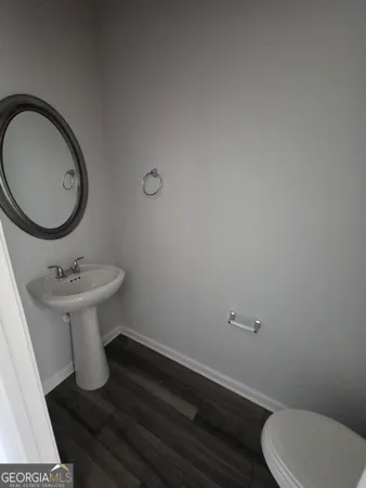 a bathroom with a sink toilet and a mirror