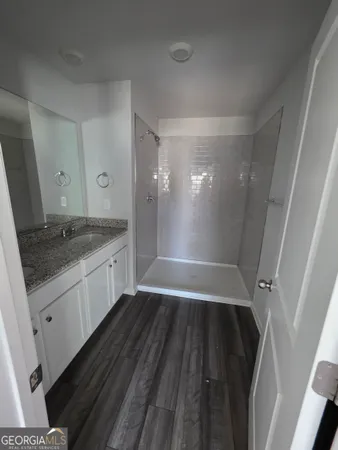 a bathroom with a granite countertop sink toilet and shower