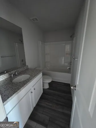 a bathroom with a granite countertop sink and toilet