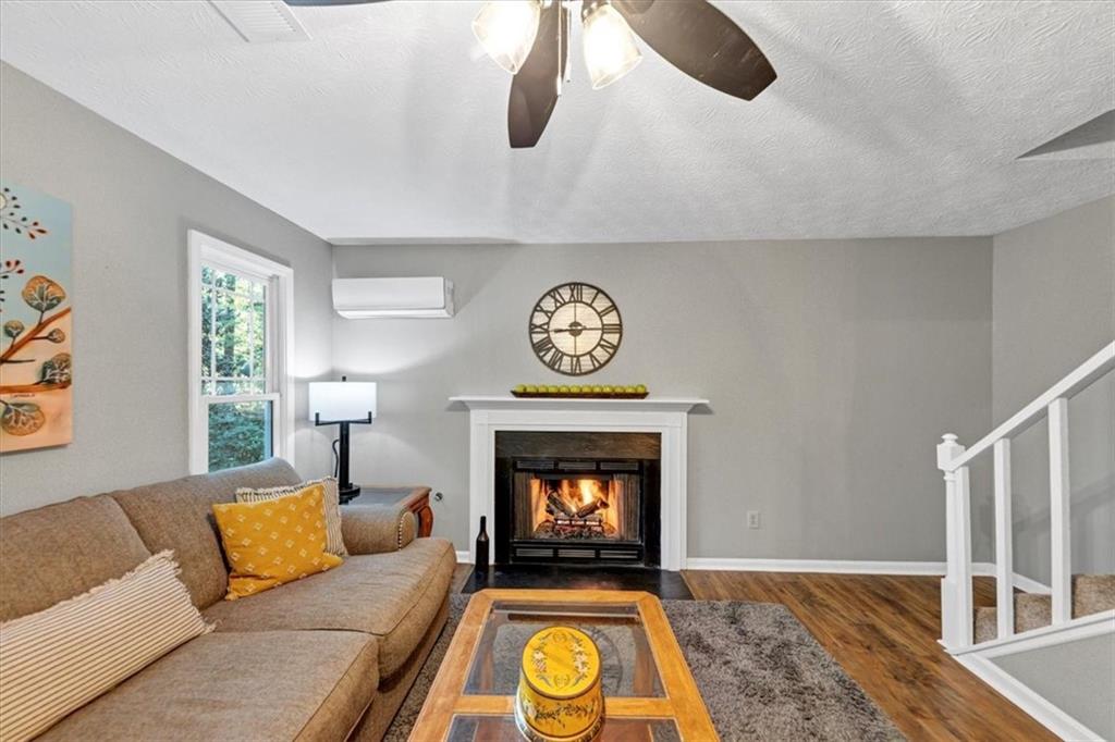 2710 Braemore Place Powder Springs, GA 30127 - Photo 21 of 53 a living room with furniture a rug and a fireplace