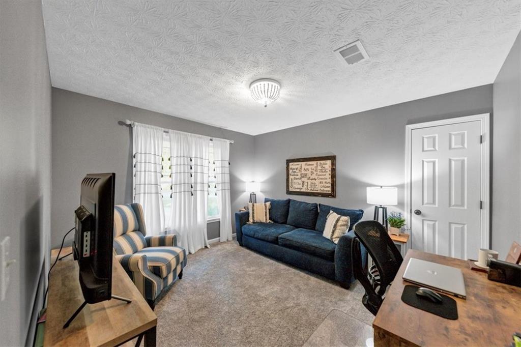 2710 Braemore Place Powder Springs, GA 30127 - Photo 28 of 53 a living room with furniture a flat screen tv and a window