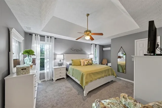 a bedroom with a bed and a flat tv screen on the dresser