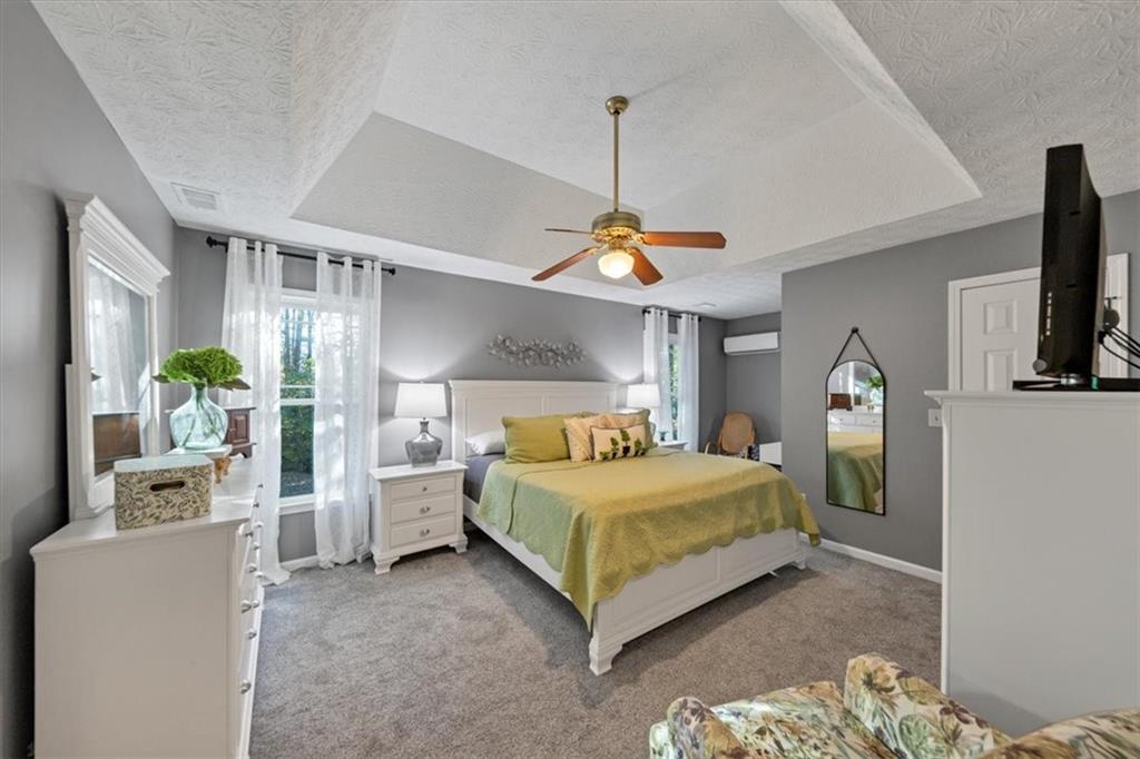 2710 Braemore Place Powder Springs, GA 30127 - Photo 31 of 53 a bedroom with a bed table and flat screen tv