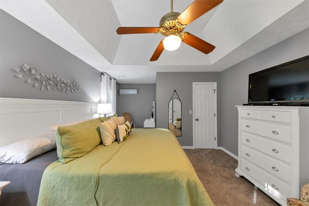 2710 Braemore Place Powder Springs, GA 30127 - Photo 32 of 53 a bedroom with a bed and a flat tv screen on the dresser