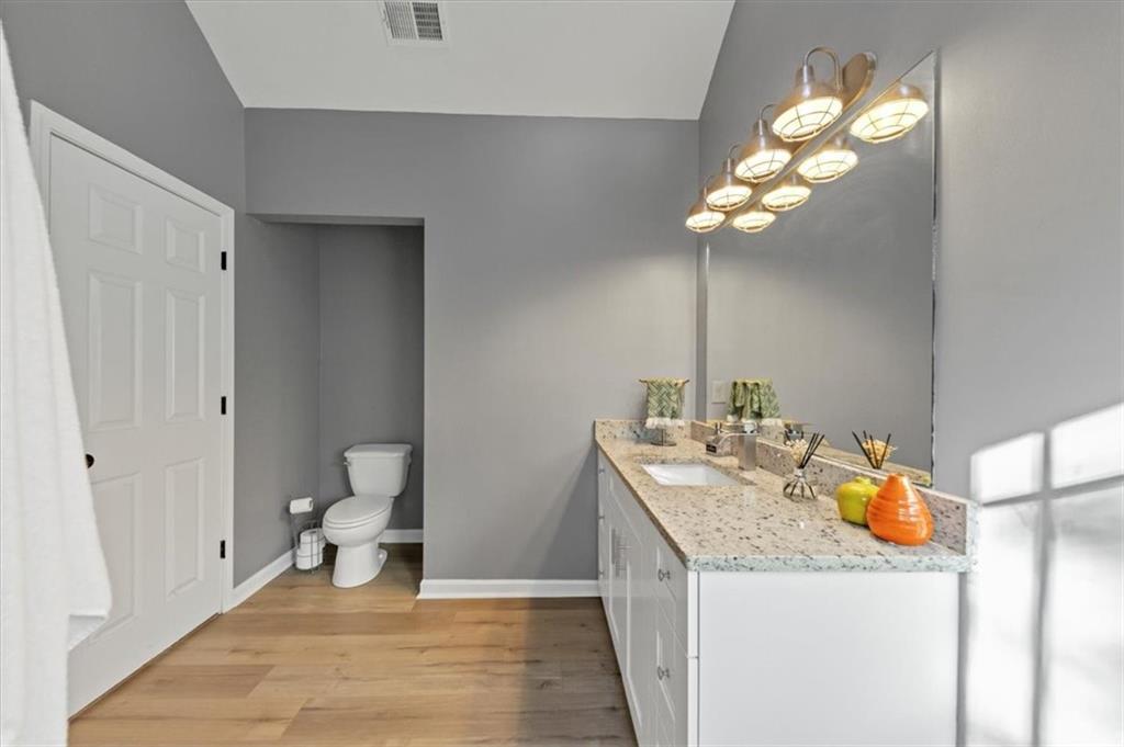 2710 Braemore Place Powder Springs, GA 30127 - Photo 38 of 53 a bathroom with a granite countertop sink a toilet and a mirror