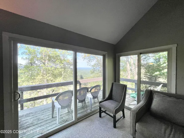 a living room with furniture and a floor to ceiling window