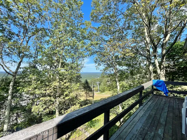 a view of a balcony with wooden floor and fence