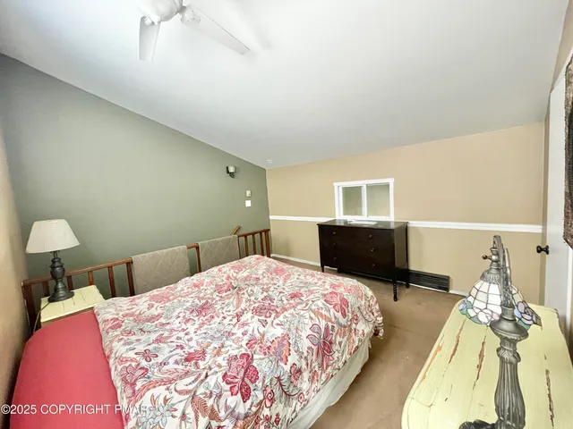 a bedroom with a bed and a flat tv screen on dresser