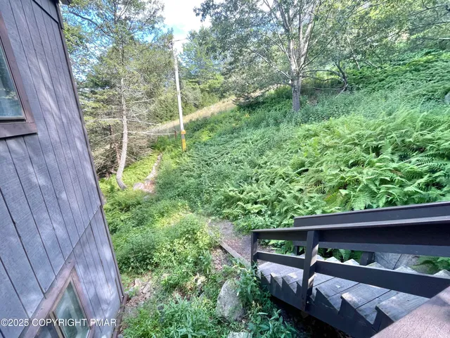 a view of a wooden deck and a backyard