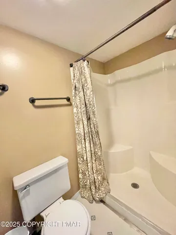 a bathroom with a toilet and shower