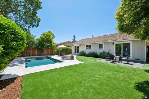 a view of a house with backyard sitting area and garden