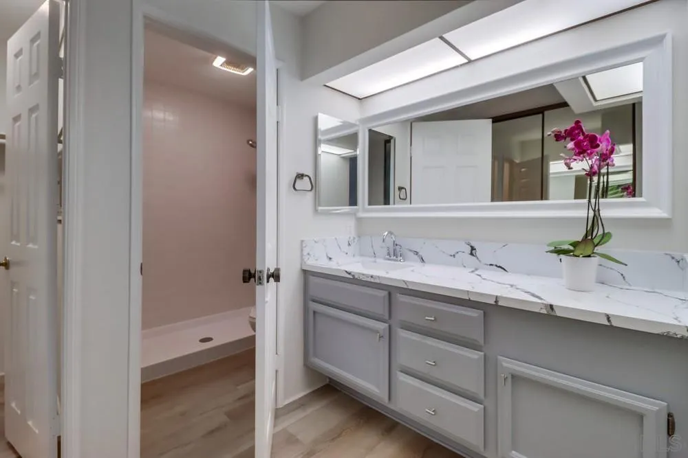 5665 Friars Road, Unit 219 San Diego, CA 92110 - Photo 20 of 34 a bathroom with a granite countertop sink double vanity and a mirror