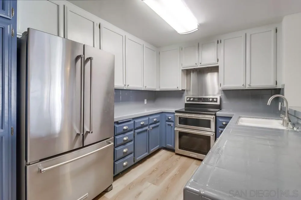 5665 Friars Road, Unit 219 San Diego, CA 92110 - Photo 3 of 34 a kitchen with stainless steel appliances granite countertop a refrigerator stove and sink