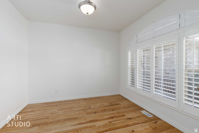 2327 Bluff Ridge Drive Syracuse, UT 84075 - Photo 10 of 66 Room featuring wood-finish flooring, white walls, and a multi-pane window with arched transom and plantation shutters