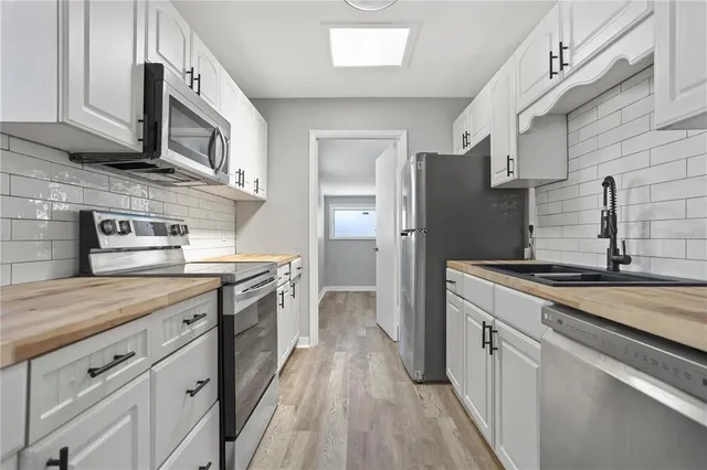 a kitchen with a sink dishwasher a stove and a refrigerator