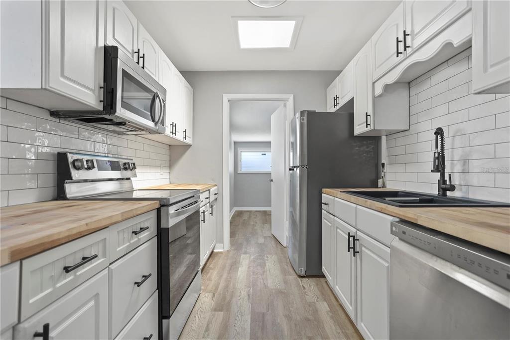 6615 Renssalaer Drive Bradenton, FL 34207 - Photo 7 of 31 a kitchen with a sink dishwasher a stove and a refrigerator