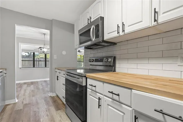a kitchen with stainless steel appliances granite countertop a sink a stove and cabinets