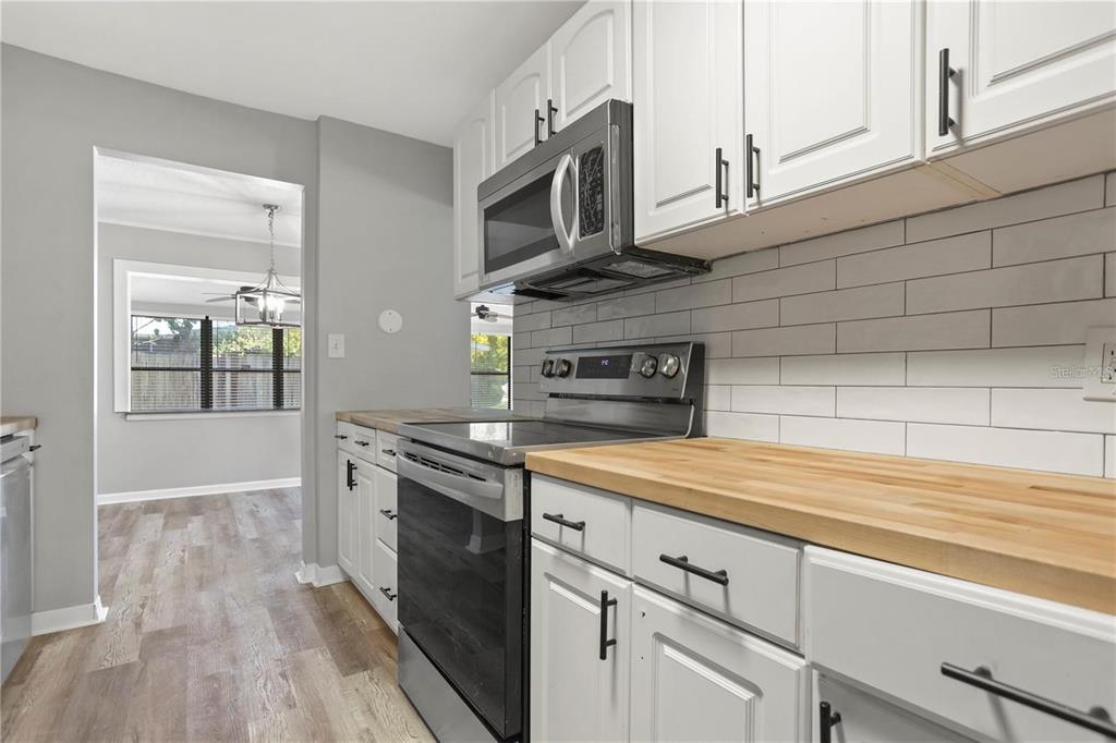 6615 Renssalaer Drive Bradenton, FL 34207 - Photo 8 of 31 a kitchen with stainless steel appliances granite countertop a sink a stove and cabinets