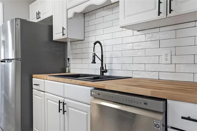 a white kitchen with a sink and cabinets